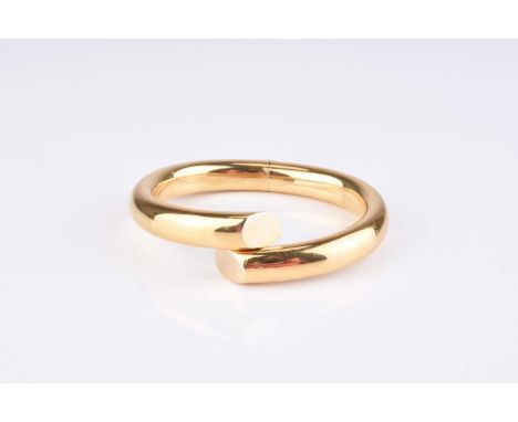 A yellow metal hinged bangle, of polished form with central hinge to the base, inner width approx 60mm, weight approx 36.5g