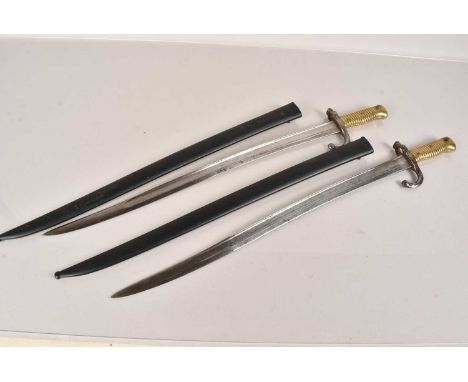 Two French Yataghan Bayonets and scabbards, one dated 1868, the other 1874, various stamps and serial number to the guards (2