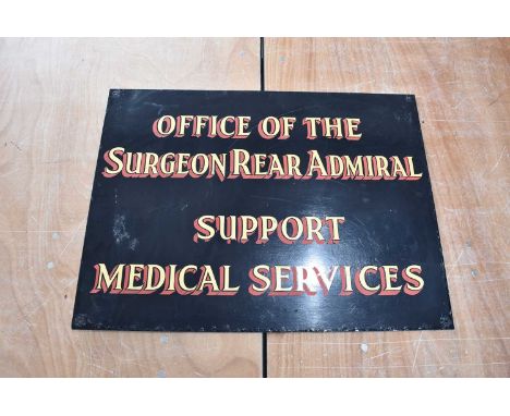 A vintage glass sign for the 'Office of the Surgeon Rear Admiral Support Medical Services', gilt text, with red shadowing, on