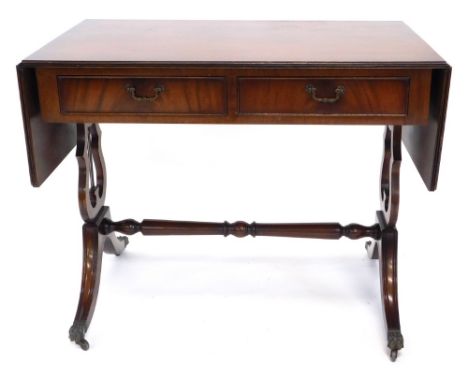 A mahogany and ebony strung sofa table in Regency style, with a reeded edge above two frieze drawers, on lyre shaped supports