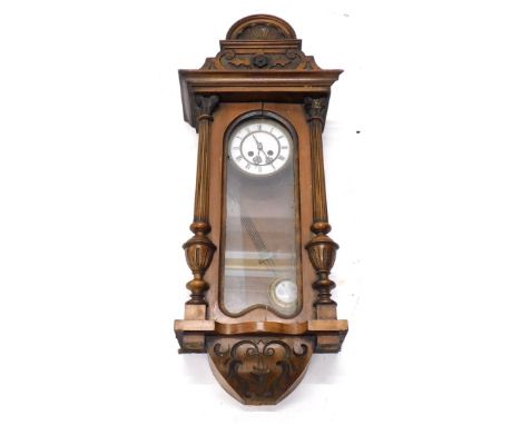 A late 19th/early 20thC Vienna wall clock, in a walnut case with white enamel dial, flanked by two part reeded pilasters, 83c