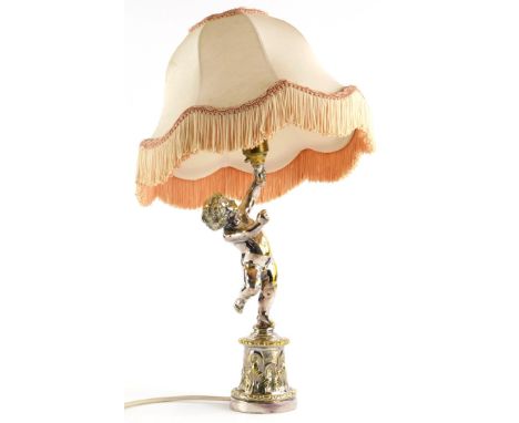 A silver plated brass table lamp, modelled in the form of a putto on a cylindrical base with shade, 42cm high overall.