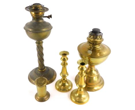 A late Victorian brass oil lamp, decorated with scrolls, etc., on a fluted base, another brass oil lamp, a pair of candlestic