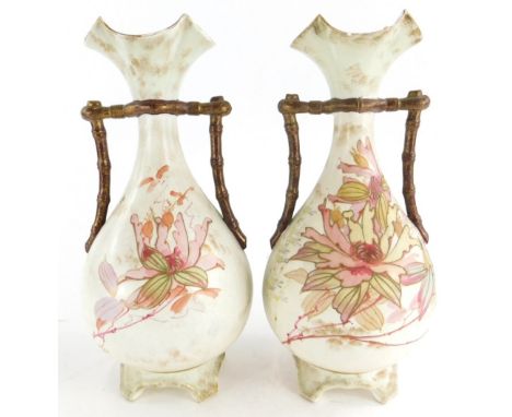 A pair of Moore and Co blush ivory ceramic vases, each decorated with flowers, 27cm high.