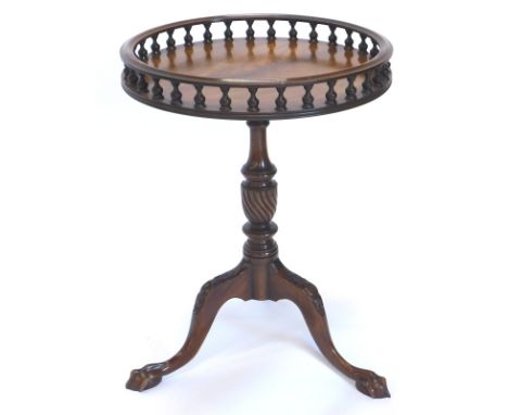 A mahogany occasional table, the circular top with a spindle turned gallery on a turned part fluted column and carved tripod 