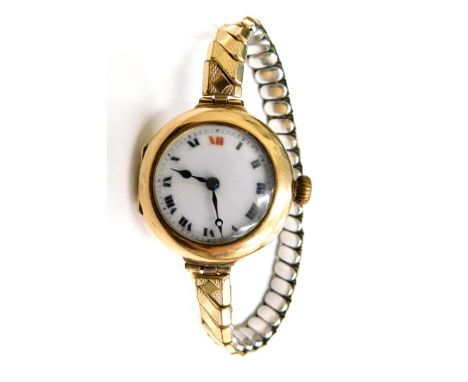 A late 19thC 9ct gold cased wristwatch, the white enamel dial with Roman numerals, in a 9ct gold casing, on an expanding late