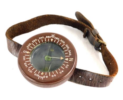 A WWII US Army Airborne wrist compass, in brown Bakelite with leather strap.Provenance: acquired by the vendor Saint Mere Egl