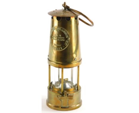 A brass protector miner's lamp, 25cm high.