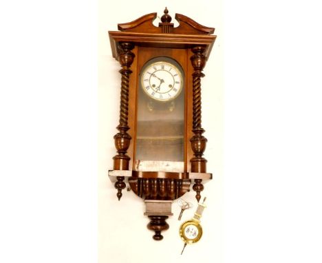 A late 19th/early 20thC Vienna wall clock, in a walnut case with a white enamel dial, 66cm long.