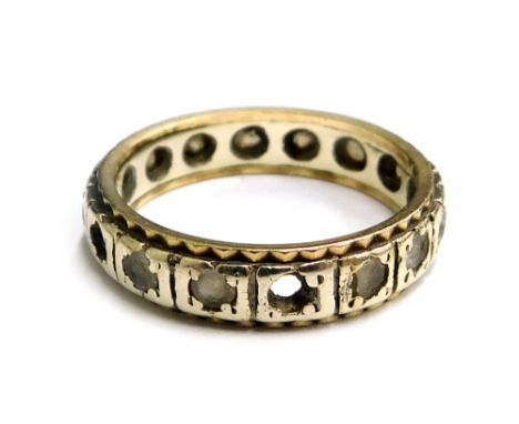 An eternity ring, set with white paste stones in a white metal setting, unmarked, ring size M½, 3.6g all in. (AF)