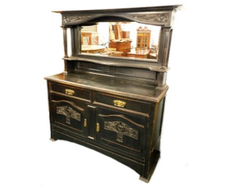 A late 19th/ early 20thC ebonised oak sideboard, the top with a carved crest, above a bevelled mirror plate and a shelf with 