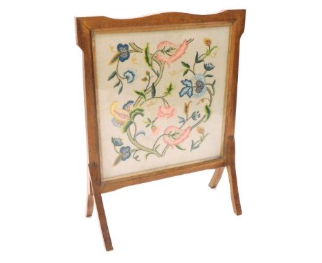 An early 20thC Arts and Crafts oak firescreen, with crewel work banner, 65cm wide.