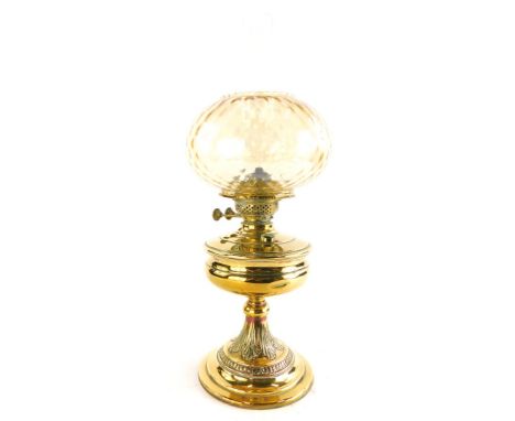 A Victorian brass oil lamp, with leaf cast column and stepped domed foot, later associated shade, 54cm high overall.