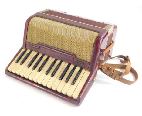 A small piano accordion, in red marbled case, possibly Italian, 32cm wide.