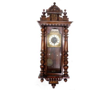 A Vienna wall clock, in a walnut case with part enamel and brass dial, flanked by a pair of pilasters, also including two ass