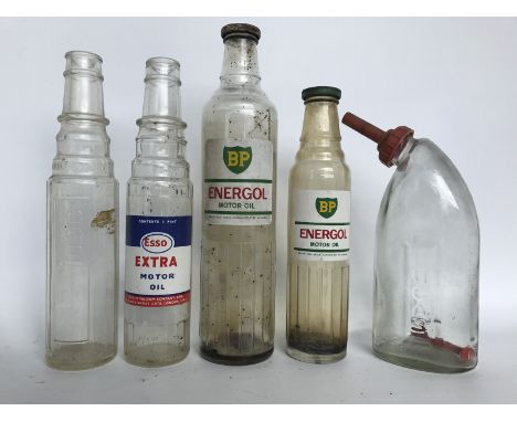 Two BP Energol Motor Oil glass bottles, two Esso oil bottles and a Lucas glass battery top-up dispenser. 