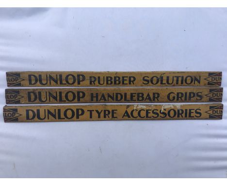 Three Dunlop shelf strips advertising 'rubber solution', 'handlebar grips' and 'tyre accessories'. 