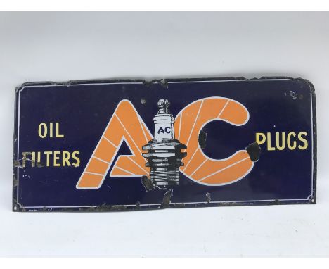 A small AC Plugs and Oil Filters rectangular enamel sign with central plug image, 21 x 9".