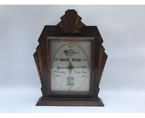 An unusual Art Deco table barometer set within an oak frame, the dial advertising AC - Britains Leading Light Car.