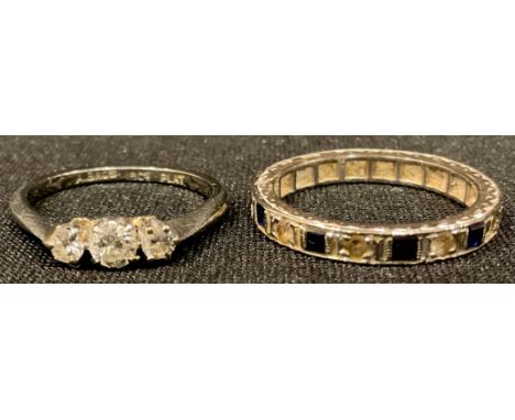 An 18ct gold three stone diamond ring, size K, 2g; an 18ct gold diamond and sapphire eternity ring, marked 18, London 1971, 3