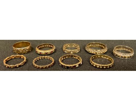 A 9ct gold nonagon eternity ring set with clear stones, size R; other 9ct golf eternity rings set with stones, a 9ct gold ban