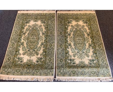 A pair of Persian Isfahan type Rugs, the wool pile and silk carpets in subdued shades of green and jade on white, each measur