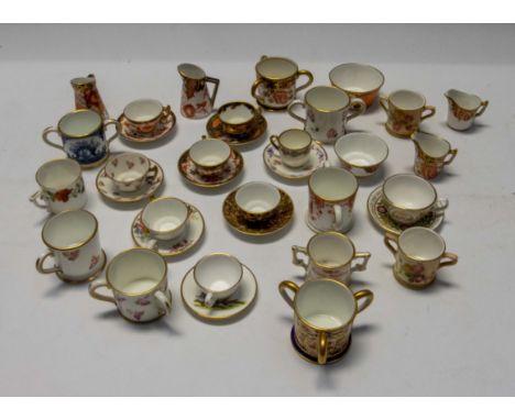 A collection of Royal Crown Derby early to mid 20th Century miniatures to include cups with saucers, twin handled mugs, sugar