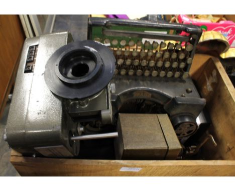 A vintage royal black metal typewriter along with 1950s scientific equipment in wooden cases and metal car jacks.