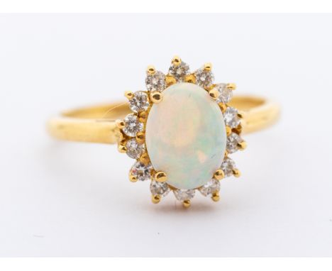 An opal and diamond oval 18ct gold cluster ring, set with an oval opal, approx 7.9mm, within a border of small round brillian