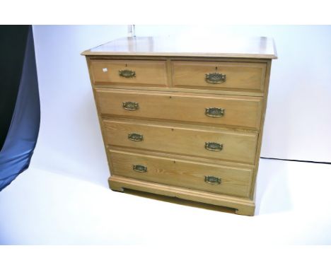 A set of Edwardian two over three chest of light oak drawers with swing handles, standing on bracket feet.