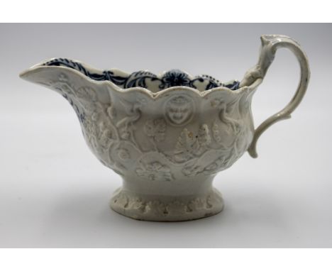 A Liverpool rare blue and white sauce boat finely moulded with a mask, Liver birds and vines. The handle is in the form of a 
