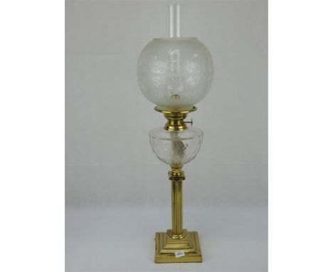 An early 20th Century brass oil lamp with reeded classical column, facet cut reservoir and etched globe shade. Overall height