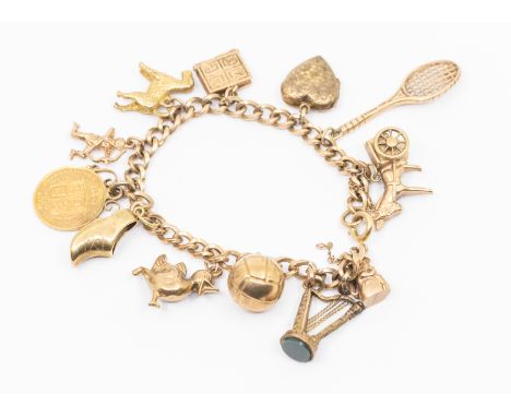 A 9ct gold link chain bracelet suspending various 9ct gold and yellow metal charms to include 9ct gold football, toby jug duc