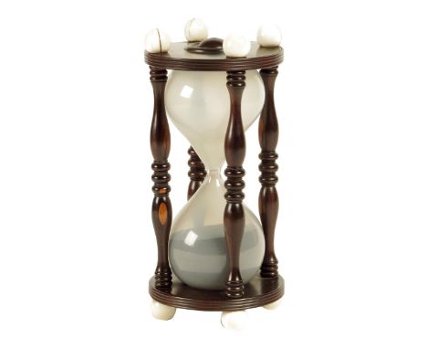 λ An early 19th century turned lignum vitae and ivory sand glass, with ball finials and glass hourglass bulbs, the sand runs 