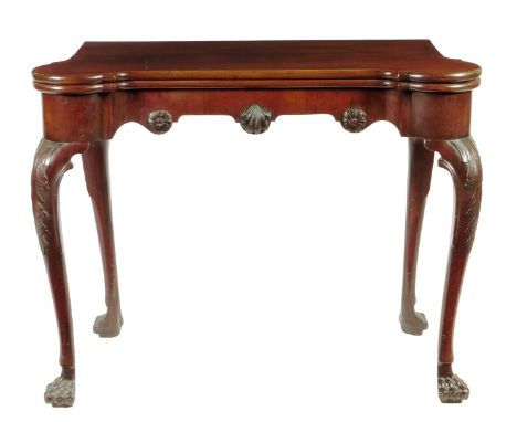 A George II Irish mahogany card table, the fold-over top with protruding corners revealing a baize lined surface with candle 