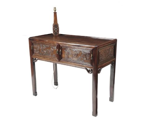A Chinese hardwood side table, the galleried top with an integral carved lamp above a pair of frieze drawers carved with figu