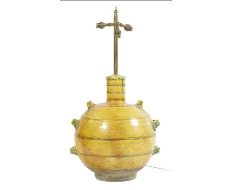 A pottery lamp, with a yellow and green lead glaze and lug handles, with a brass fitting for three lights, 77cm high.