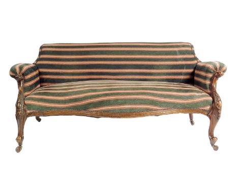 A Victorian walnut serpentine two seater sofa, later upholstered with Robert Kime striped chenille, with a carved frame on ce