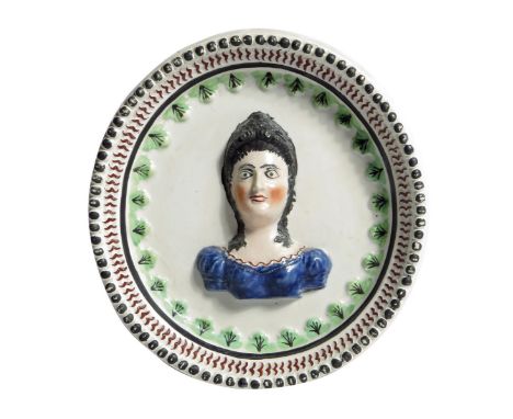 A George III Staffordshire pearlware pottery rondel, decorated with a portrait bust of Queen Charlotte, with a moulded frame,