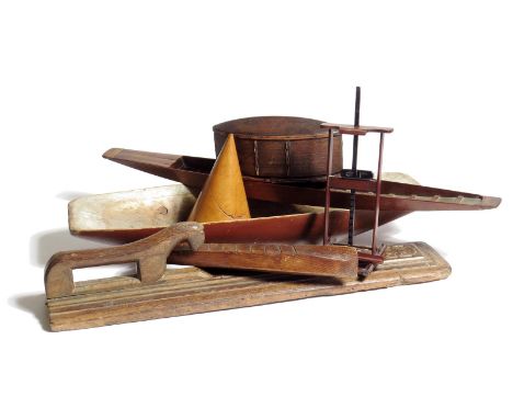 A Scandinavian mangle board, carved with a horse handle, a Scandinavian bentwood box and cover, two model wood canoes, one of