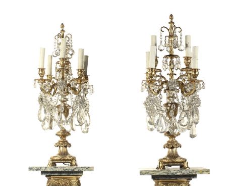 A pair of French ormolu six light candelabra in Louis XVI style, each with scroll arms and hung with faceted cut glass drops,