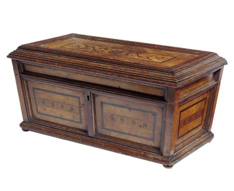 A large 19th century burr oak tea caddy in the manner of George Bullock, inlaid with bog oak marquetry and flowerheads of sar