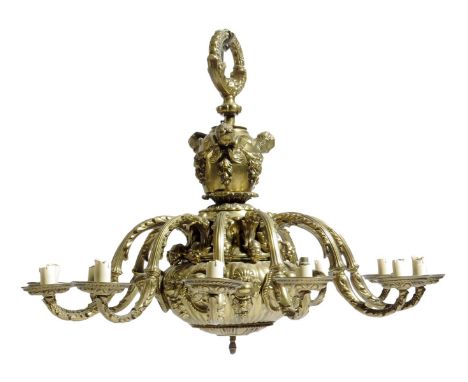 A gilt brass twelve light chandelier in Louis XIV style, the stem decorated with winged angel masks above a lobed body with f