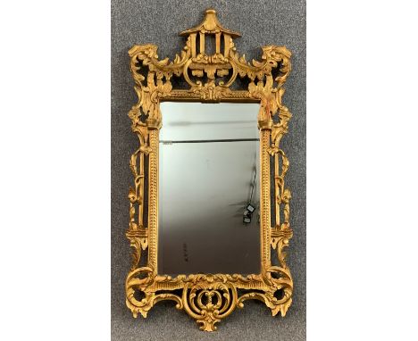 A carved giltwood wall mirror in the Chinese Chippendale style with bevelled plate. H.161 W.82cm 