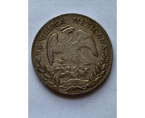 A Mexican 8 Reales Coin dated 1868.  *CR:  slight wear to surfaces.  *BP 22.5% (18.75% plus VAT) plus a lot fee of £8 inc. VA