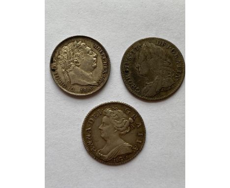 A collection of three Sixpence coins: Queen Anne Sixpence dated 1703, Vigo beneath the draped bust, A George II Sixpence date