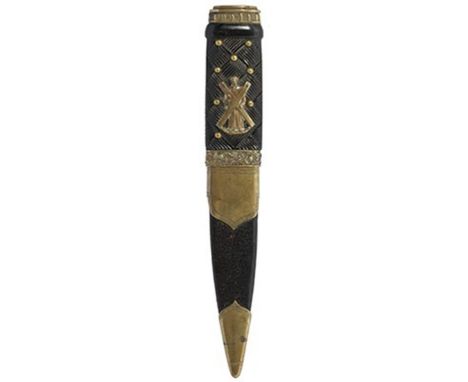 A brass mounted Sgian Dubh to the Black Watch, 10cm fullered blade with faceted back edge, the brass mounted wooden hilt carv