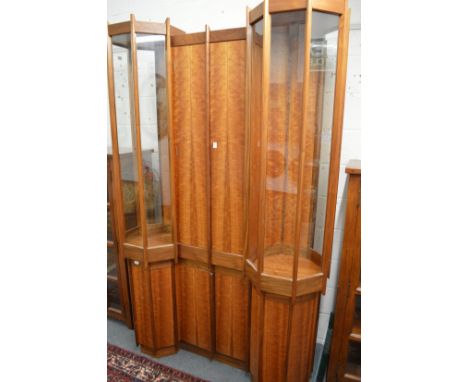 A unique walnut display cabinet on stand with four central doors flanked by octagonal shaped display units and cupboards belo