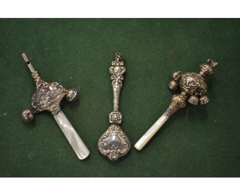 Three silver rattles, two with mother-of-pearl handles and bells.