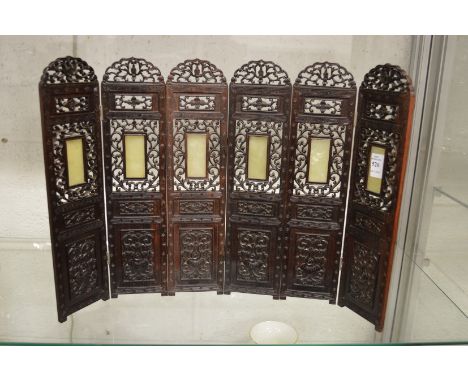 A good Chinese carved and pierced hardwood miniature six panel folding screen inset with jade panels.